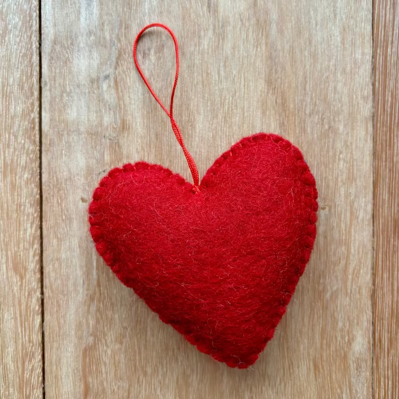 Back view of the Red heart-shaped ornament on a wooden surface