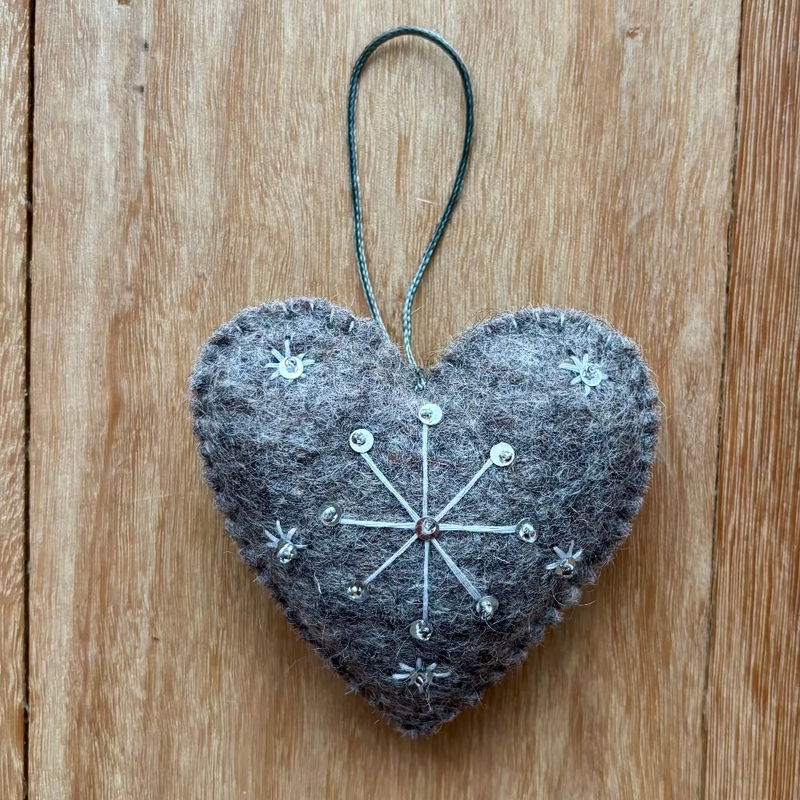 Heart-shaped decorative ornament with a star design on a wooden surface