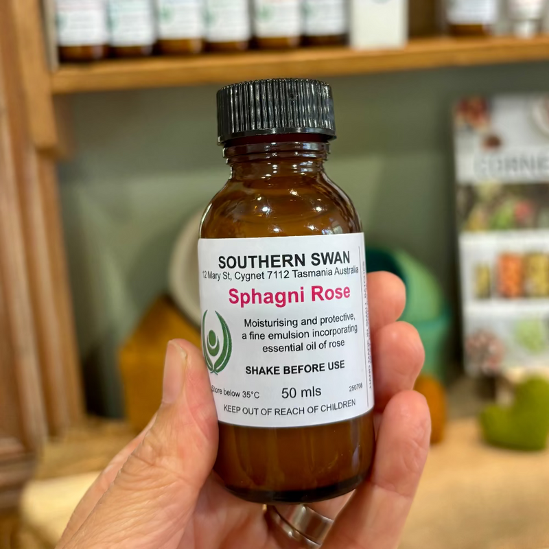 Hand holding a 50ml bottle of Southern Swan Sphagni Rose body oil