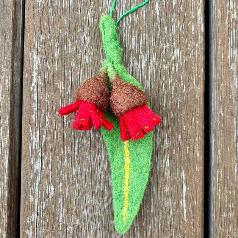 Felted  gum flower ornament on a wooden surface