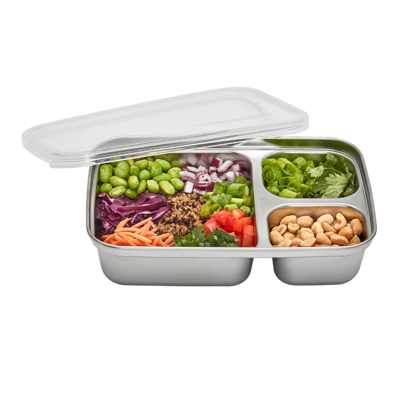 Stainless steel 3 compartment food container with silicone lid showing a variety of vegetables and nuts.
