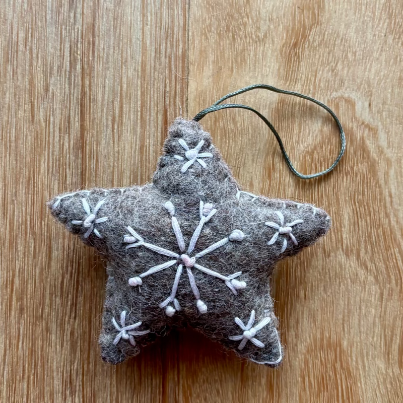 Star-shaped ornament with snowflake patterns on a wooden surface
