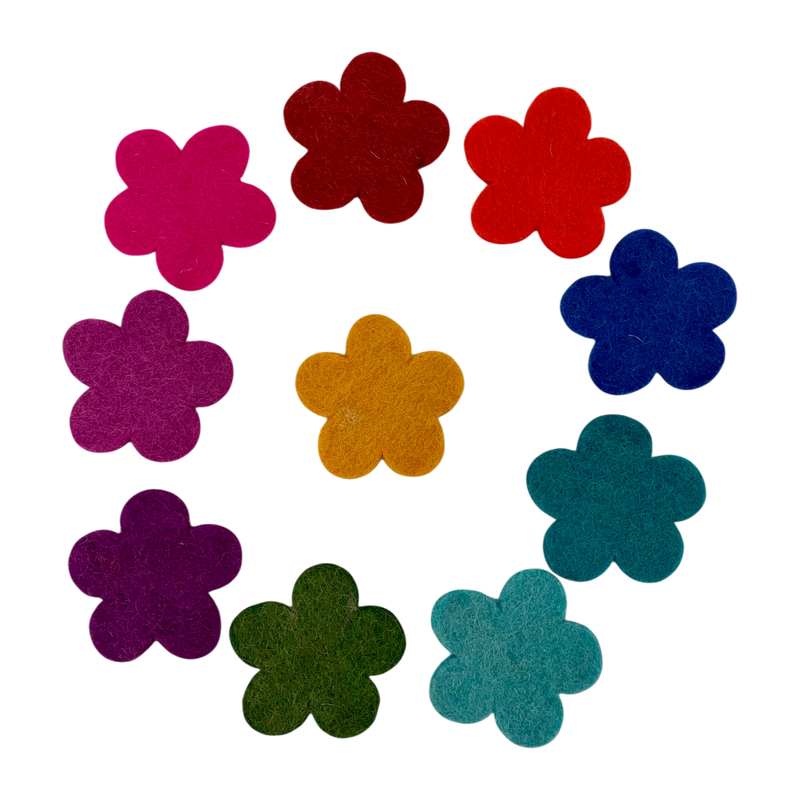 Colorful die-cut felt flowers arranged in a circular pattern on a white background