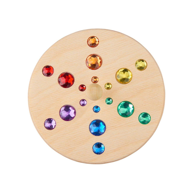 Round wooden Spinning Top with colourful gemstones on a white background